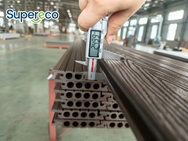 Quality inspector measuring profile thickness for hollow wpc decking using a digital caliper.