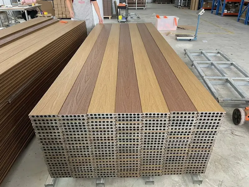 Teak and brown wood grain composite decking boards in factory