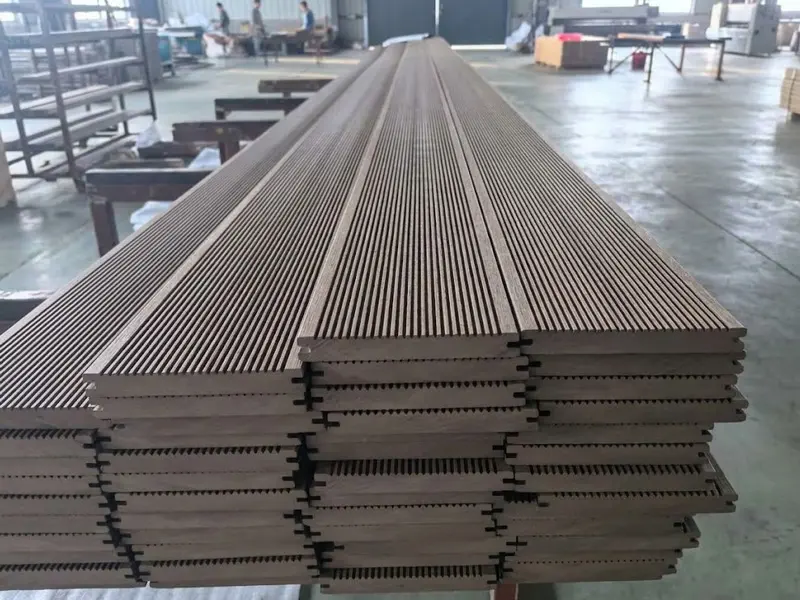 Stacked solid WPC decking boards with grooved surface in factory workshop