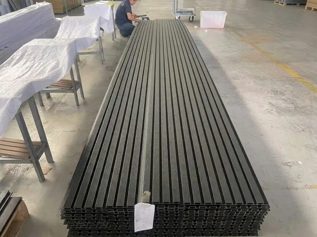 Batch of long composite decking and wall panels inspected inside the workshop prior to global shipment.