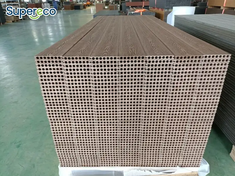 Stacked WPC decking boards showing round hollow core channels at the cut ends